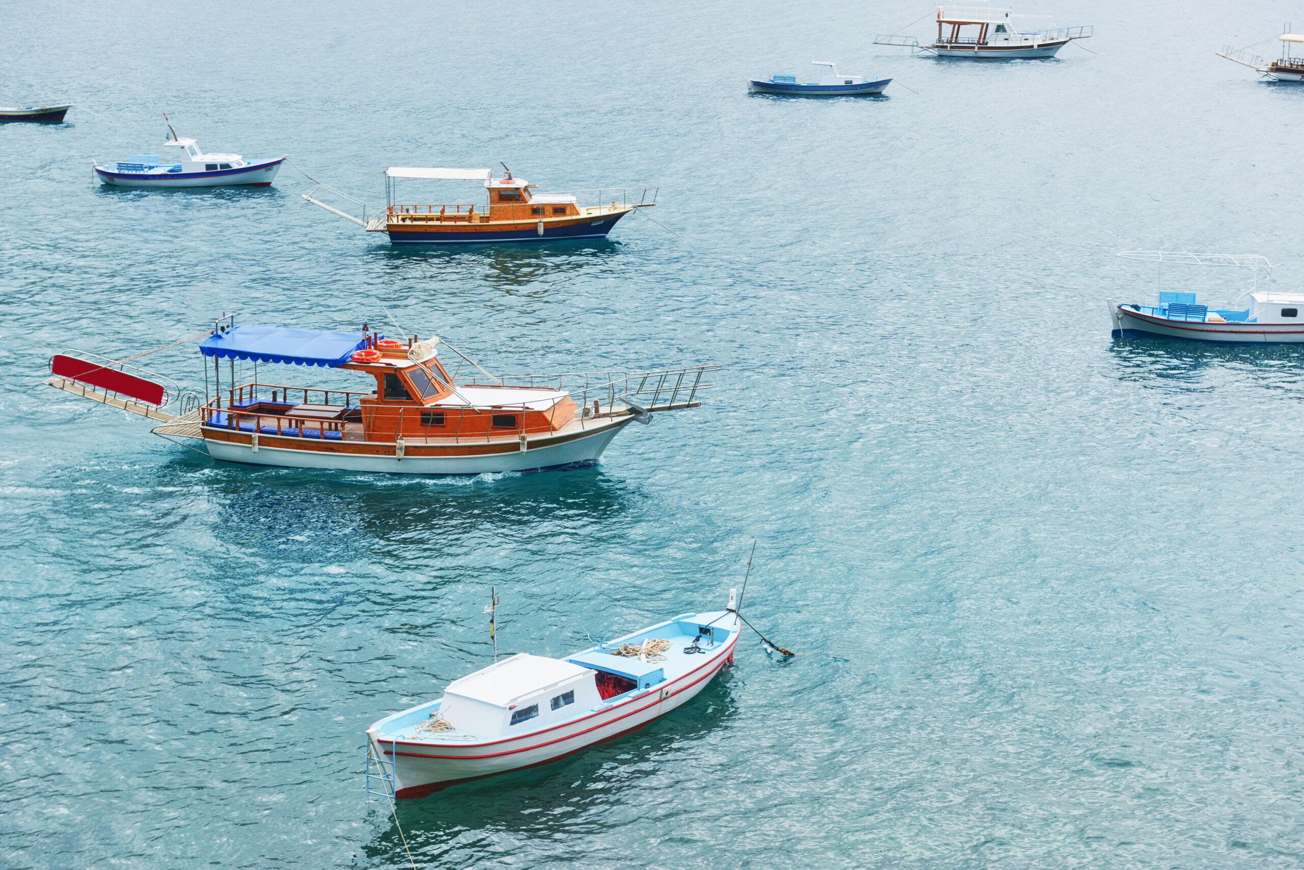 Boats float in the calm blue sea water in Turkey